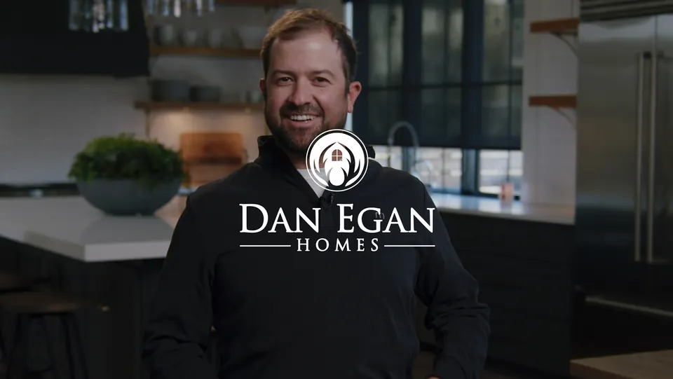Dan Egan standing in a kitchen beside the Dan Egan Homes logo
